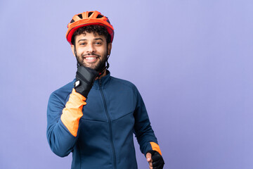 Young Moroccan cyclist man isolated on purple background celebrating a victory - obrazy, fototapety, plakaty