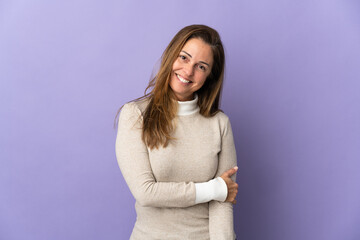 Middle age Brazilian woman isolated on purple background laughing