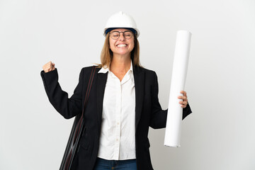 Middle age architect woman with helmet and holding blueprints over isolated background doing strong gesture