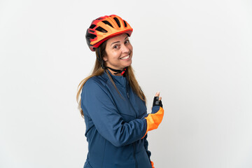 Middle age cyclist woman isolated on white background pointing back