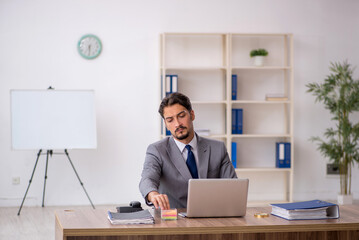 Obraz premium Young male employee sitting in the office