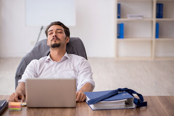 Young male employee sitting in the office