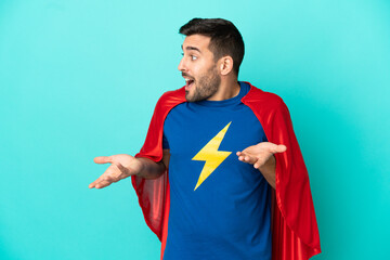 Super Hero caucasian man isolated on blue background with surprise facial expression
