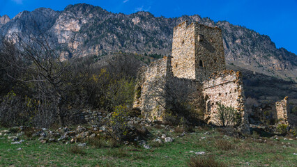 Fototapeta na wymiar An abandoned medieval town. Military and residential ancient towers built of stones. Landscape in the mountains with a view of the ruins. An ancient city in the mountains.