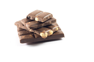 Chocolate pieces with hazelnuts isolated on white background. Hazelnut chocolate bar pieces tower. Stock photo.