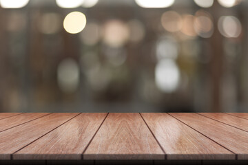 Empty wooden table top with lights bokeh on blur restaurant background.