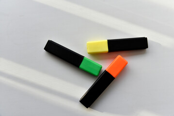 Colored markers on a white background in the light