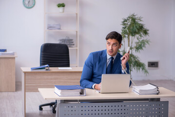 Fototapeta premium Young male employee sitting in the office