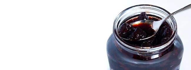 Sour cherry jam in glass jar, isolated on white background.