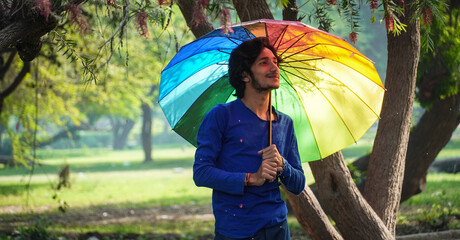 Happy Asian Boy holding Colorful umbrella in summer outdoor
