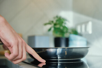 Steel frying pan in the kitchen on electric induction hob, Modern kitchen appliance