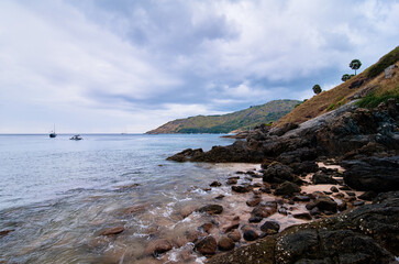 Beautiful landscape with sea, rock, stones and cloudy sky.