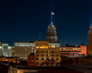 Obraz premium View of American Flag Lit Up on Top of Buiding in Downtown San Antonio, TExas