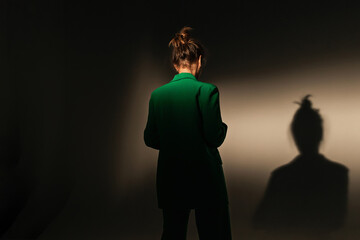 Fashion portrait of elegant trendy woman in red down jacket. Neon light, sunglasses, studio shot