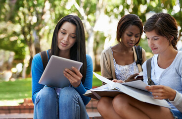 Fototapeta premium Technology makes it easier to study. Shot of a diverse group of college students sitting together outside doing online research.