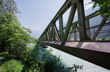 Hiking on the Swiss Alp Mountains. Metal girder bridge with pathway.