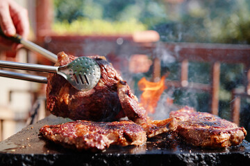Barbecue beef burger steak. Cutlet meat placed on grill stone with fire.