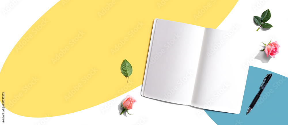 Poster open notebook or diary with a pen from above with rose buds- flat lay