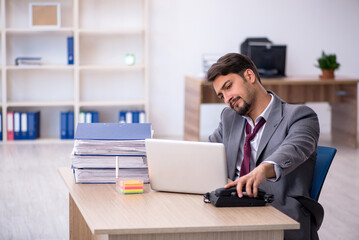 Fototapeta premium Young male employee working in the office