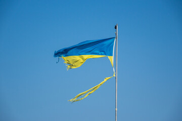 war in ukraine. Destroyed Ukrainian flag in the wind. Concept image for the Russian attack on Ukraine 