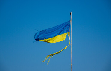 war in ukraine. Destroyed Ukrainian flag in the wind. 