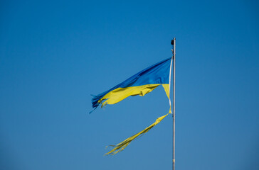 war in ukraine. Destroyed Ukrainian flag in the wind. Concept image for the Russian attack on...