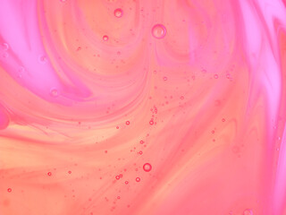 Beautiful psychedelic pink and orange abstraction formed by light on the surface of liquid soap...