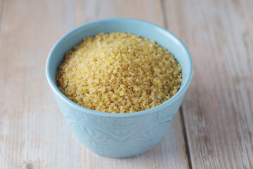 Dry uncooked bulgur in a ceramic bowl
