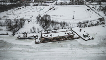 Old rusty abandoned ships on a frozen river. Winter landscape. Abandoned technology. Old shabby ships.