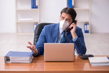 Fototapeta premium Young businessman employee working in the office during pandemic