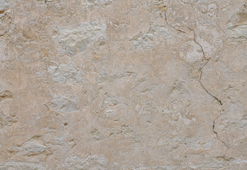 Beige stone wall with cracks. Stone background.