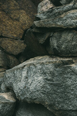 Large pile of stones. Stone rocks. Granite quarry. Abstract background. Abandoned industrial production. Vertical shot.