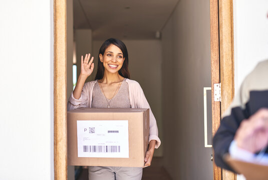 Our service will always leave you smiling. Shot of a young woman waving goodbye to a delivery man.
