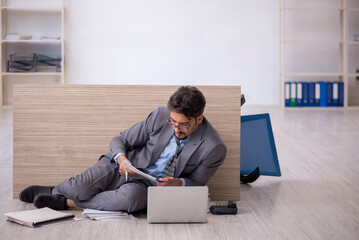 Young male employee working overtime in the office