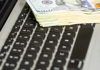 Close up of dollar banknotes on laptop keyboard, business concept