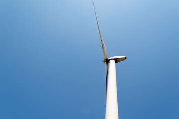 Alternative green energy sources. Wind turbine on blue sku background