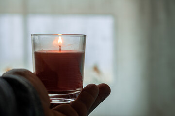 Burning candle on a male hand.