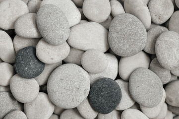 Grey, black and white stone background at the beach. Cobblestone pattern. Rocks at the seashore. 