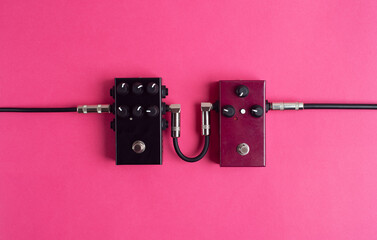 Two guitar pedals on a hot pink background. Guitar equipment. Flat lay, top view. 