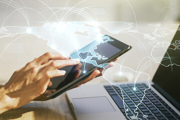 Double exposure of abstract digital world map with connections and hand working with a digital tablet on background, big data and blockchain concept