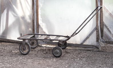 Old metal four-wheeled wheelbarrow