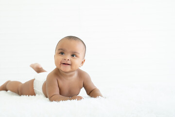 Adorable newborn Nigerian Asian baby girl wear diaper smiling with sparkling bright eyes and...