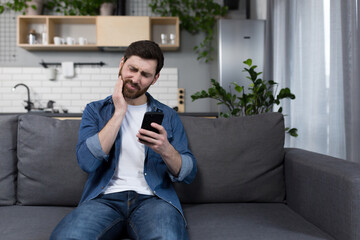 A man at home has a severe toothache, tries to call a doctor and consult online, uses the phone and...