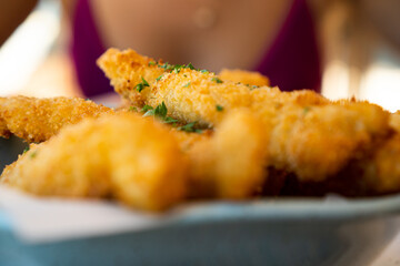 Fresh fried Brazilian tilapia fish strips with lime and tartar sauce known as isca de peixe....