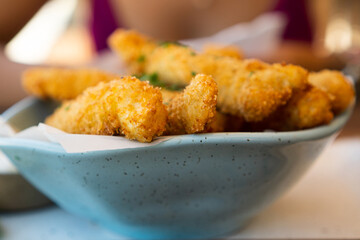 Fresh fried Brazilian tilapia fish strips with lime and tartar sauce known as isca de peixe. Traditional Brazilian appetizer. Selective focus