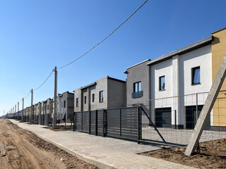 Fototapeta na wymiar Exterior view of a modern townhouse. The concept of outdoor buildings of multi-apartment residential townhouses