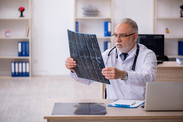 Old male doctor radiologist working in the clinic