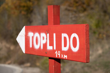 Red, wooden Signpost to the village of Topli Do on Old mountain in Serbia - 493806866