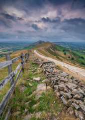 Mam Tor ridgeway, the Peak District, on a moody, cloudy summer's morning. The sky is pink where the...