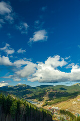 Magnificent panoramic view the coniferous forest on the mighty Carpathians Mountains and beautiful blue sky background. Beauty of wild virgin Ukrainian nature. Peacefulness.